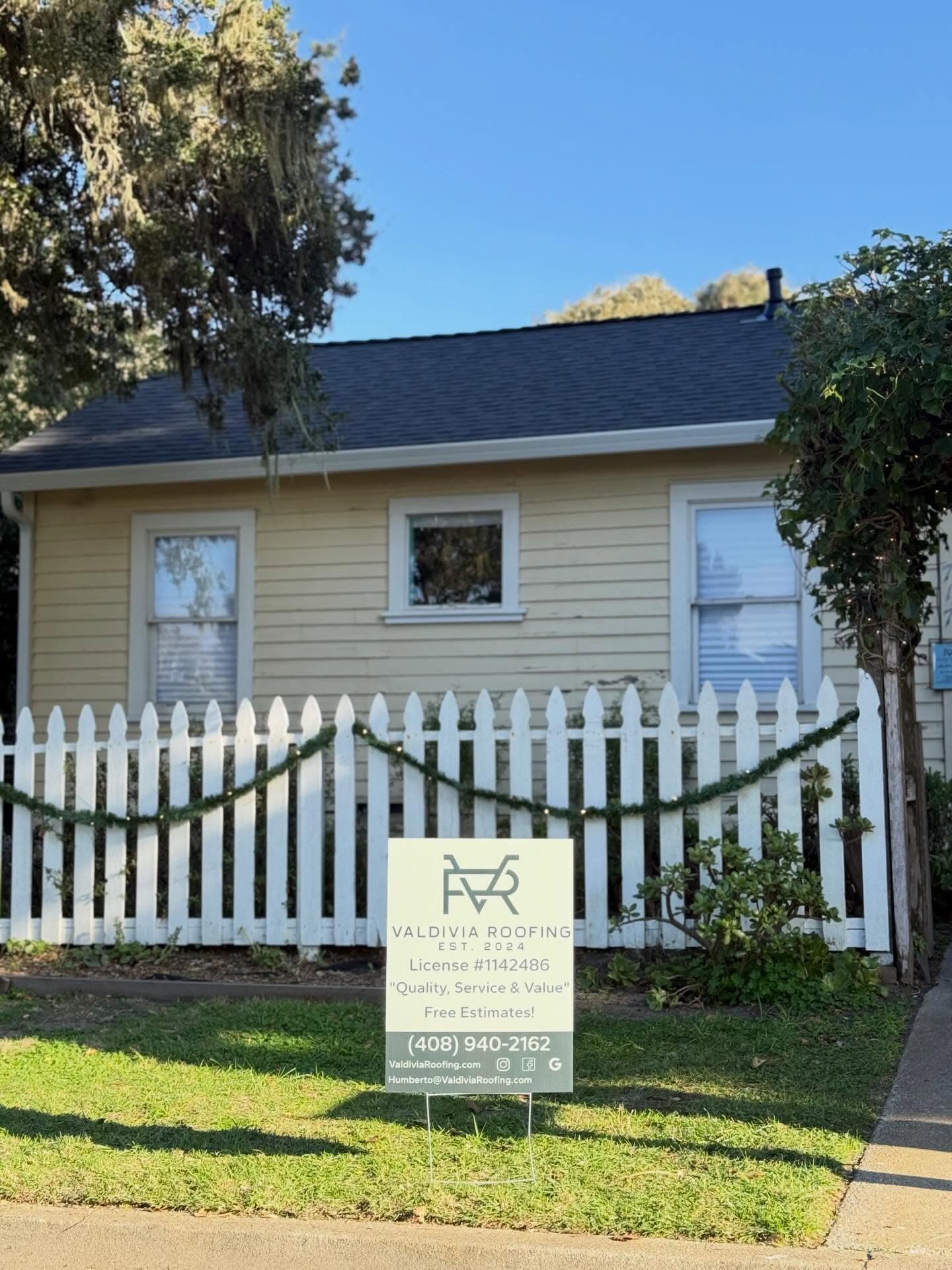 Completed residential roof with Valdivia Roofing yard sign
